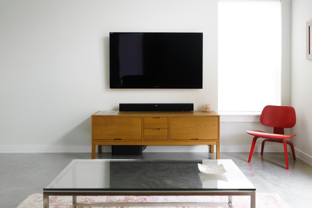 Flat screen TV mounted on a clean white wall with a soundbar